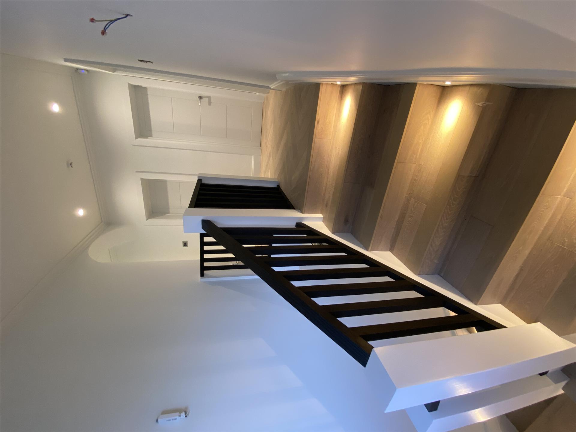 Modern staircase with LED wall lights and black railings, Essex